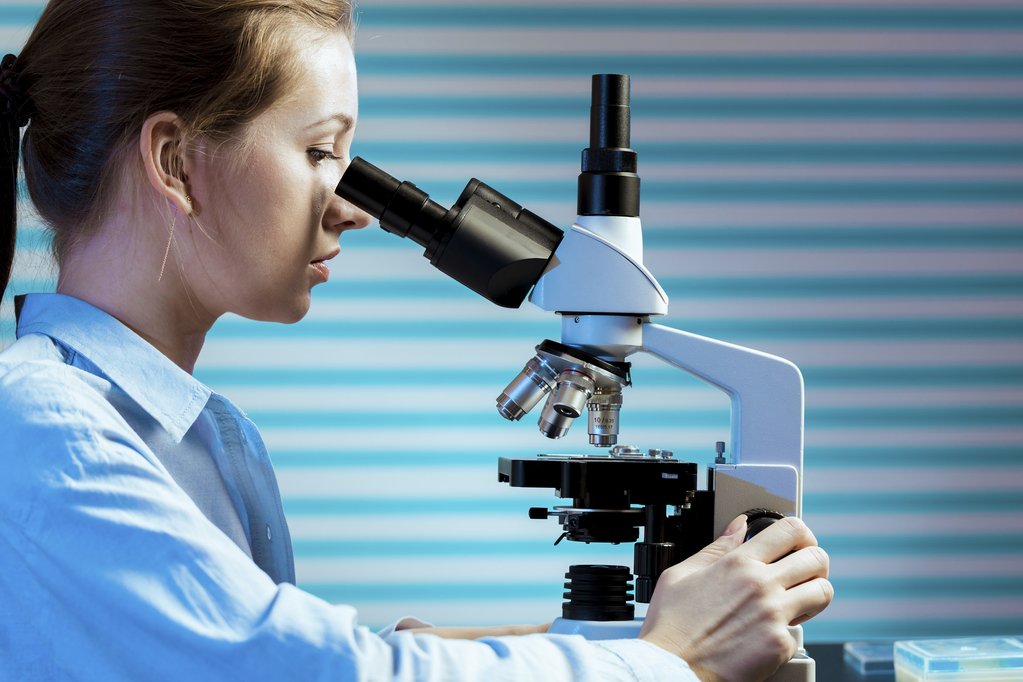 Scientist using microscope